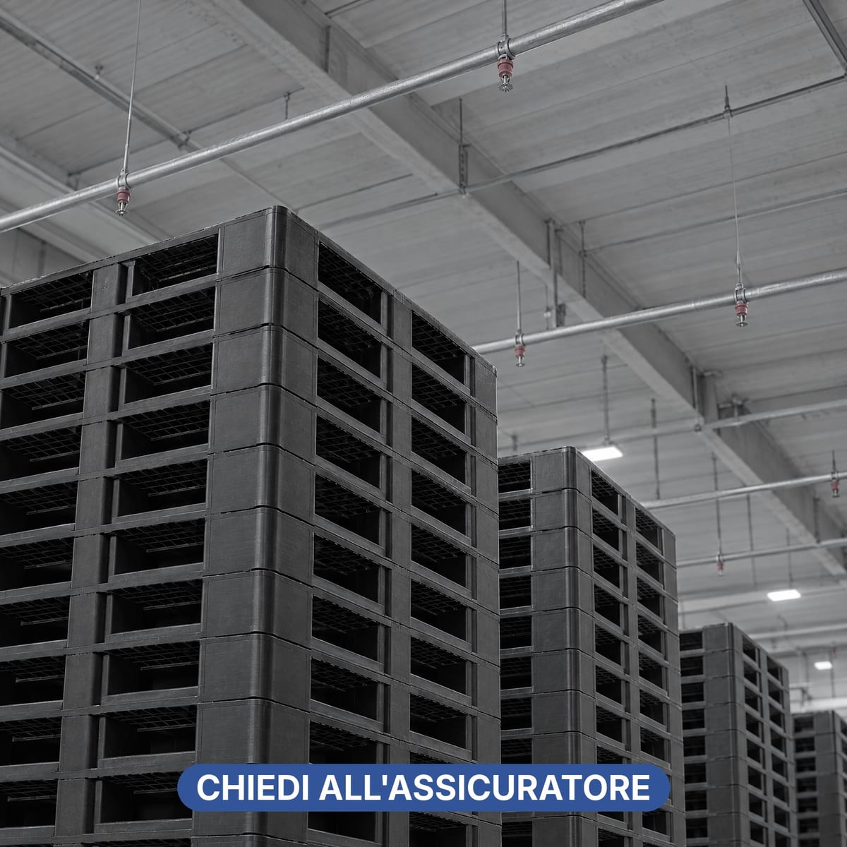 Deposito di pallet in plastica vuoti impilati sotto un impianto sprinkler a soffitto